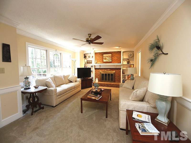 8904 Wellsley Way Raleigh, NC 27613 - Photo 12 of 25 a living room with furniture a fireplace and a large window