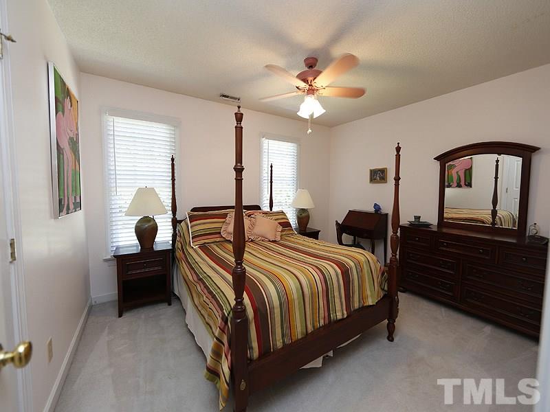 8904 Wellsley Way Raleigh, NC 27613 - Photo 19 of 25 a bedroom with a bed and ceiling fan