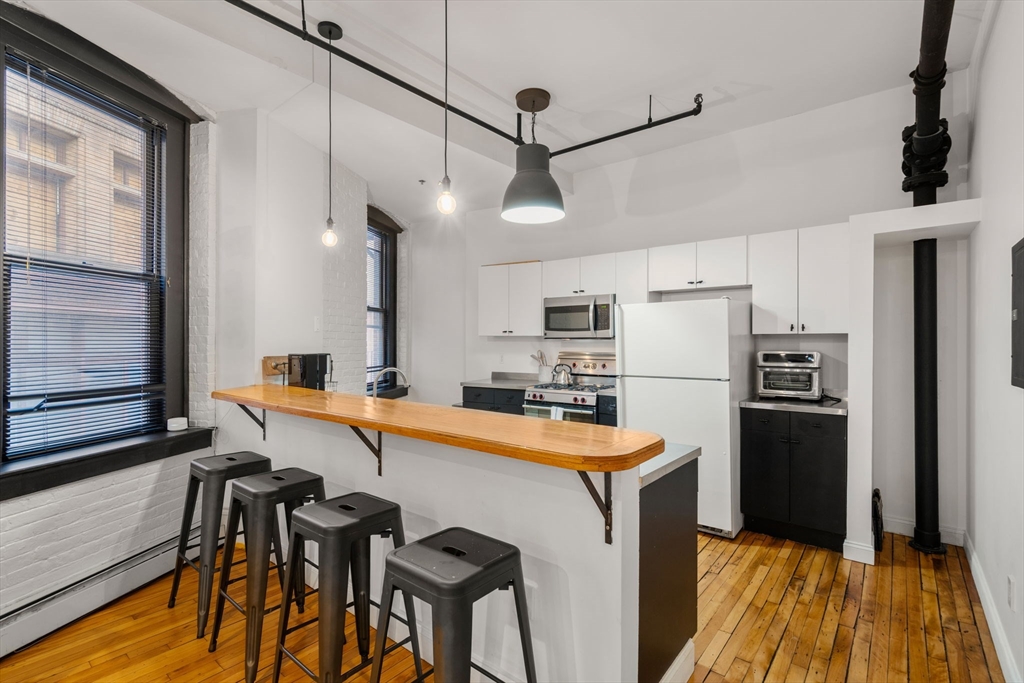 13-19 Stanhope Street, Unit 2A Boston, MA 02116 - Photo 11 of 22 a kitchen with stainless steel appliances a stove a sink refrigerator and a table