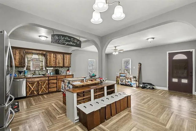 a kitchen with stainless steel appliances a stove a sink dishwasher and cabinets with wooden floor