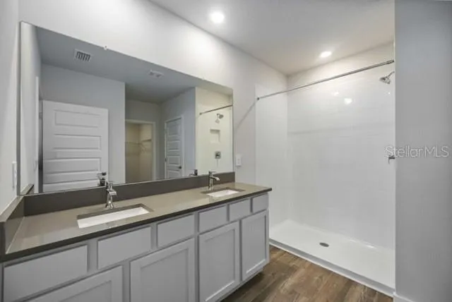 a bathroom with double sink and a mirror