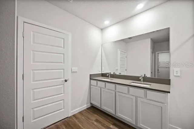a bathroom with a double vanity sink and a mirror