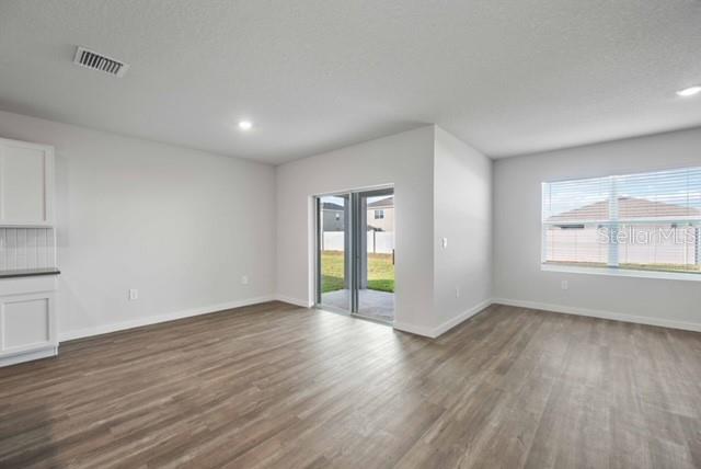 3703 Hatchery Way Lakewood Ranch, FL 34211 - Photo 4 of 35 a view of an empty room with wooden floor and a window