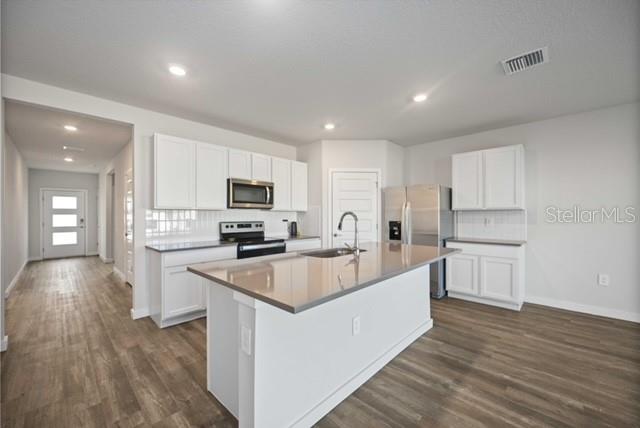 3703 Hatchery Way Lakewood Ranch, FL 34211 - Photo 10 of 35 a large kitchen with stainless steel appliances granite countertop a large center island a sink a stove and a refrigerator