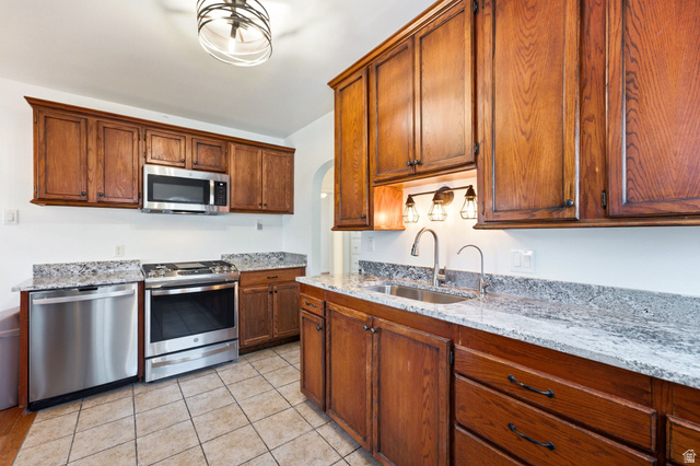 1925 South Main Street Bountiful, UT 84010 - Photo 15 of 48 Kitchen featuring wood cabinetry, stainless steel appliances, granite countertops, and tiled flooring