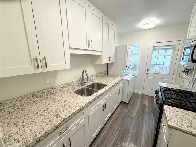 a kitchen with stainless steel appliances granite countertop a sink stove and cabinets