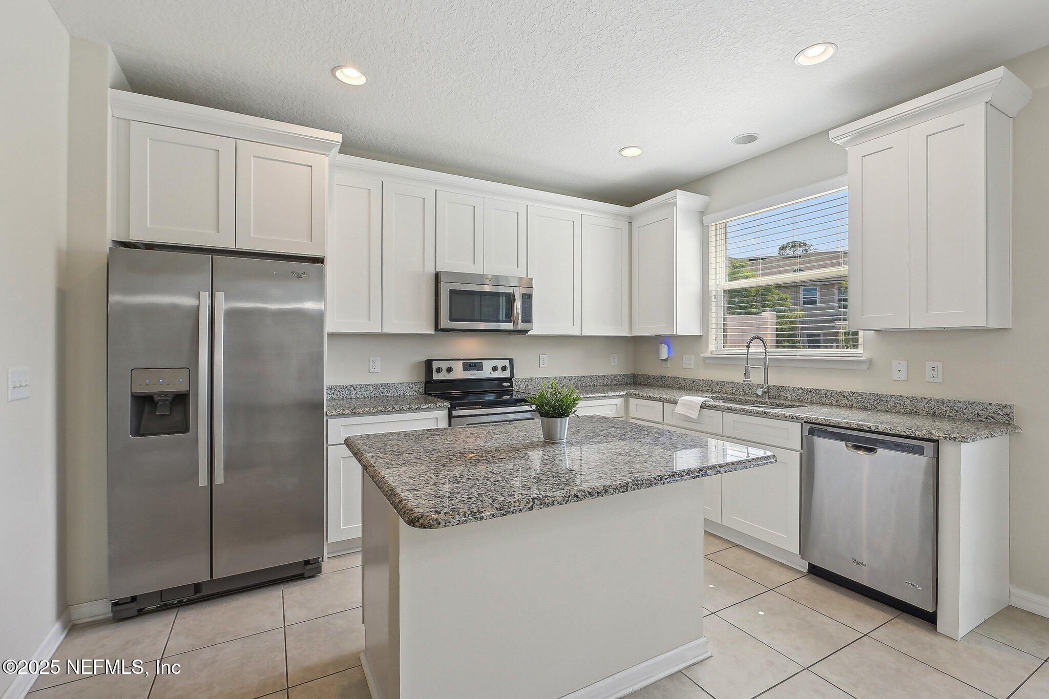 53 Nelson Lane St. Johns, FL 32259 - Photo 16 of 37 a kitchen with stainless steel appliances granite countertop a refrigerator a sink a stove a microwave and island