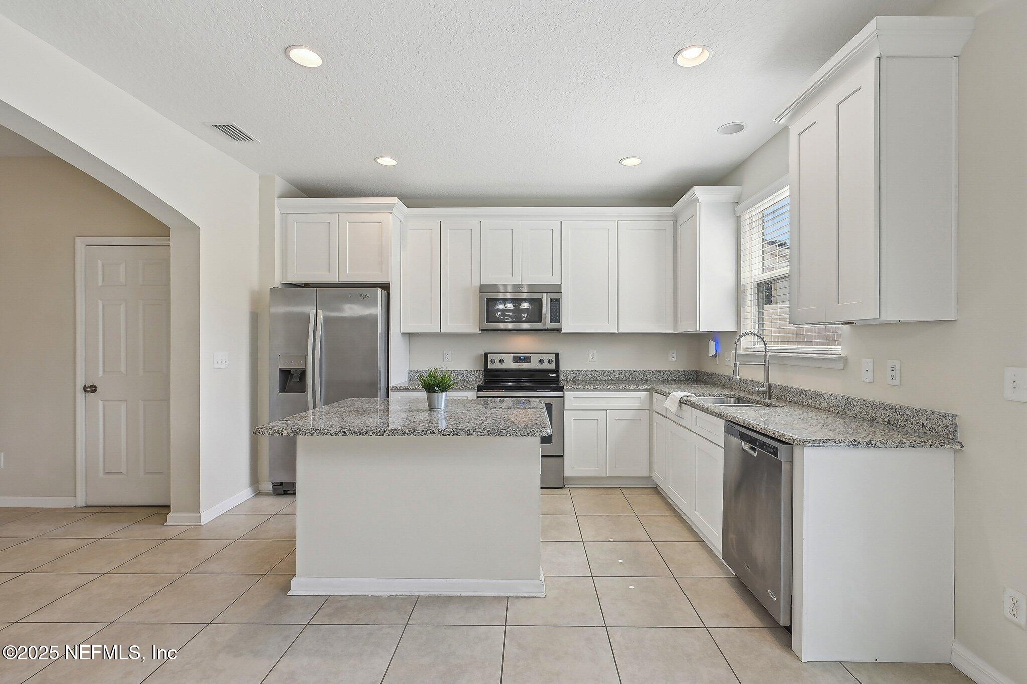 53 Nelson Lane St. Johns, FL 32259 - Photo 17 of 37 a kitchen with stainless steel appliances granite countertop a refrigerator sink and cabinets