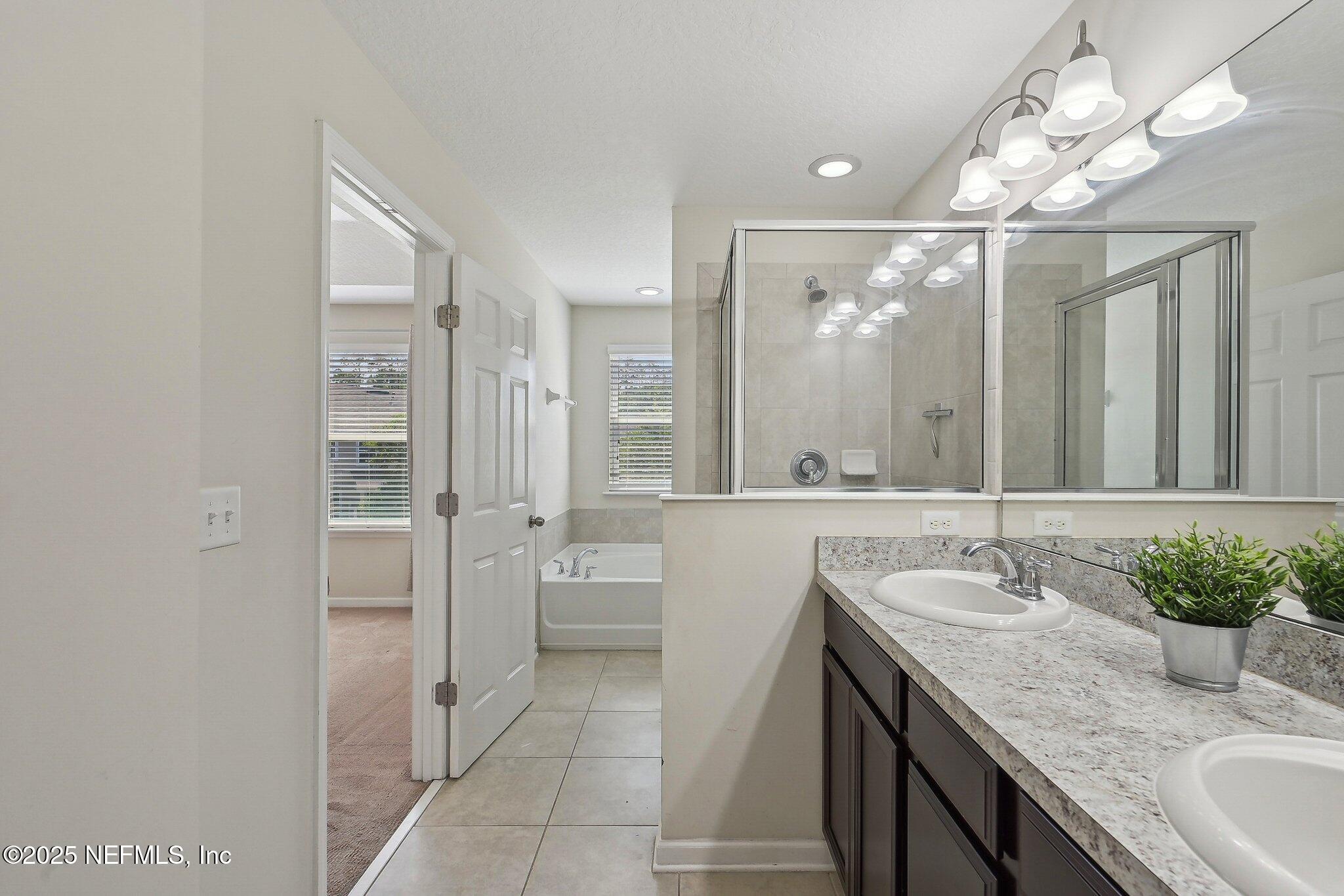 53 Nelson Lane St. Johns, FL 32259 - Photo 23 of 37 a bathroom with a granite countertop sink a large mirror and a shower
