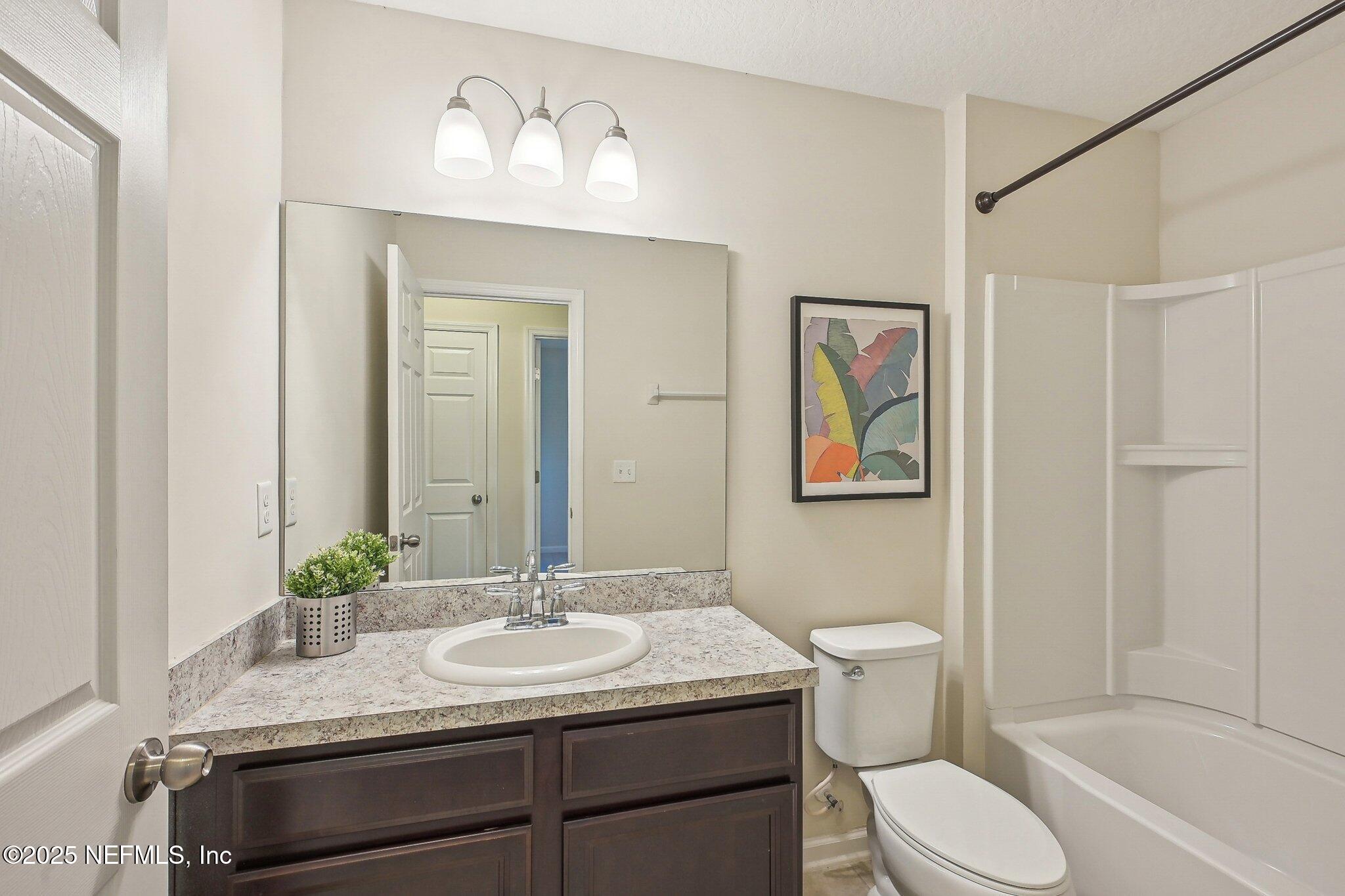 53 Nelson Lane St. Johns, FL 32259 - Photo 27 of 37 a bathroom with a granite countertop sink toilet and a mirror