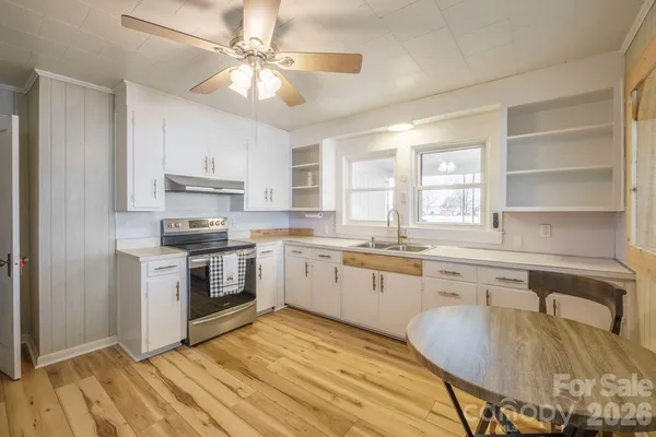 a kitchen with granite countertop a sink cabinets stainless steel appliances and a window
