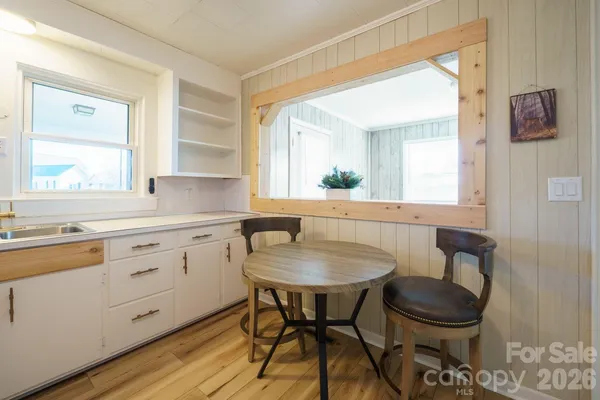 a kitchen with a table chairs sink and cabinets