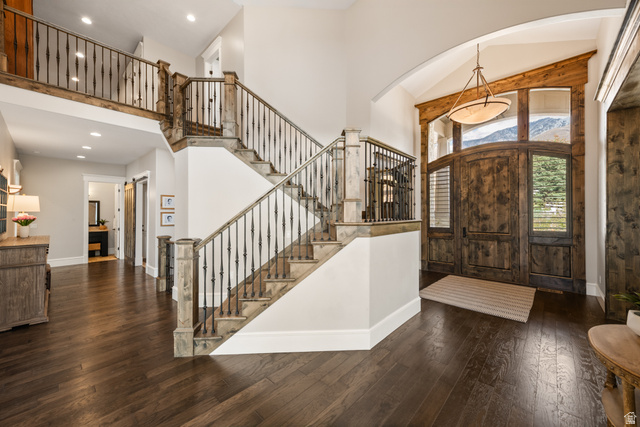 1205 North Elk Rdg Lane, Unit 202 Alpine, UT 84004 - Photo 6 of 88 Grand foyer featuring dark wood-finish flooring, a double-height ceiling, and a prominent staircase with wrought iron balusters