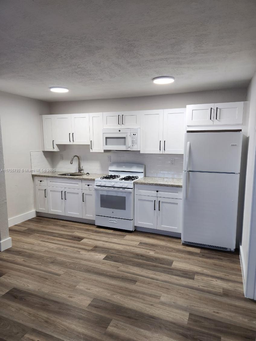 25 West 6th Street, Unit 25 Hialeah, FL 33010 - Photo 4 of 7 a kitchen with stainless steel appliances granite countertop a stove a refrigerator and a microwave