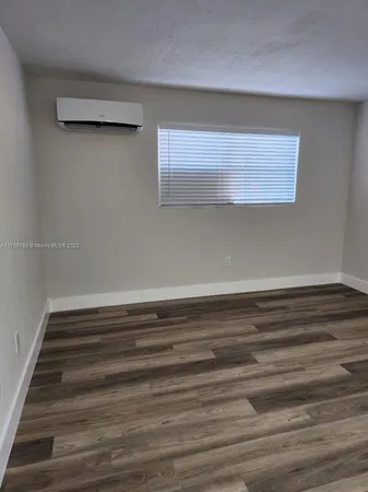 a view of an empty room with wooden floor and closet