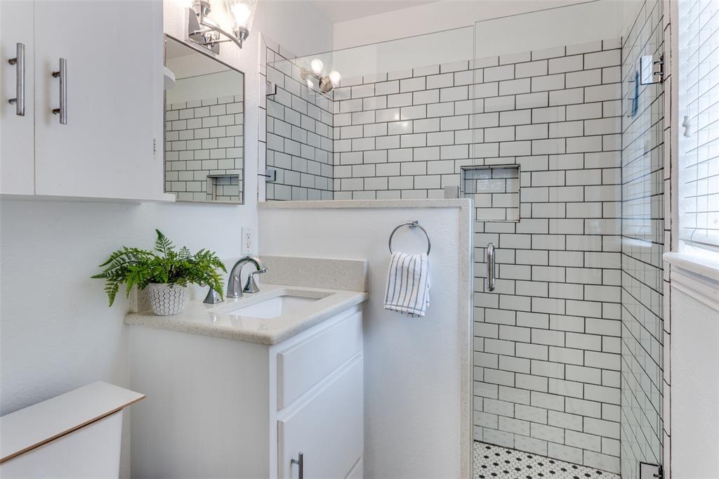 6491 Kirkwood Road Fort Worth, TX 76116 - Photo 18 of 25 a bathroom with a sink a mirror and a shower