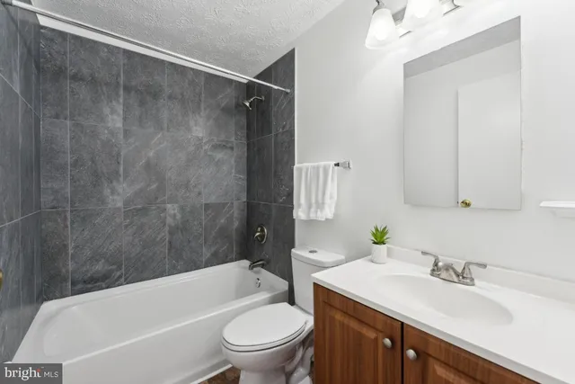 a bathroom with a sink toilet vanity and shower