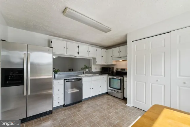 a kitchen with stainless steel appliances a refrigerator sink and cabinets