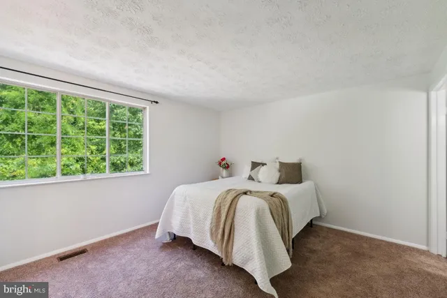a bed sitting in a bedroom next to a window