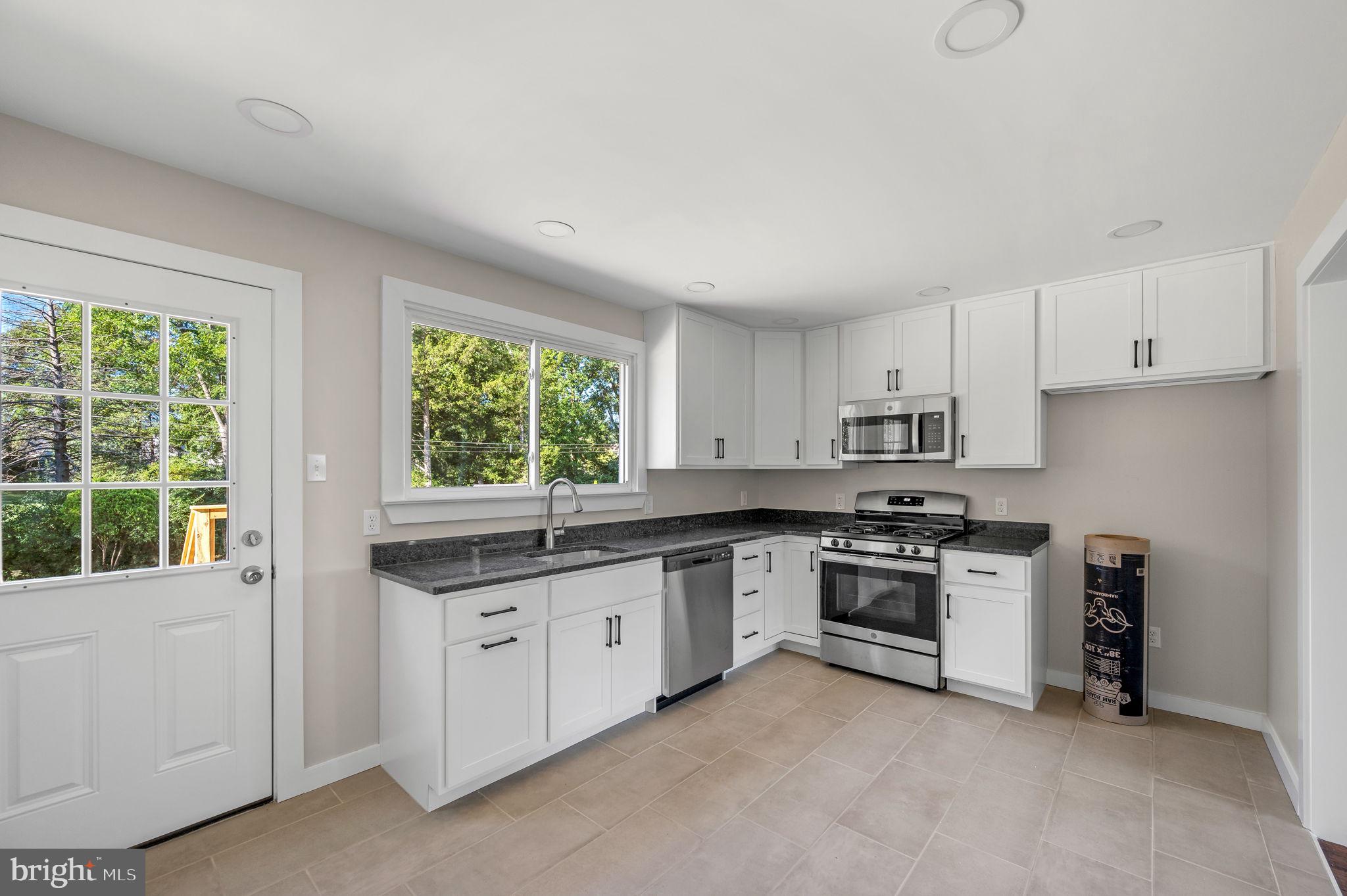 1600 Church Road Oreland, PA 19075 - Photo 8 of 22 a kitchen with stainless steel appliances granite countertop and a stove top oven