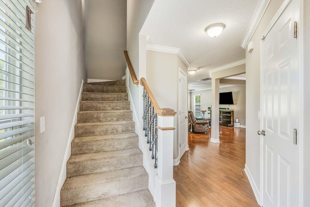 1200 Cypress Fall Circle Hinesville, GA 31313 - Photo 13 of 24 a view of a hallway with wooden floor and staircase