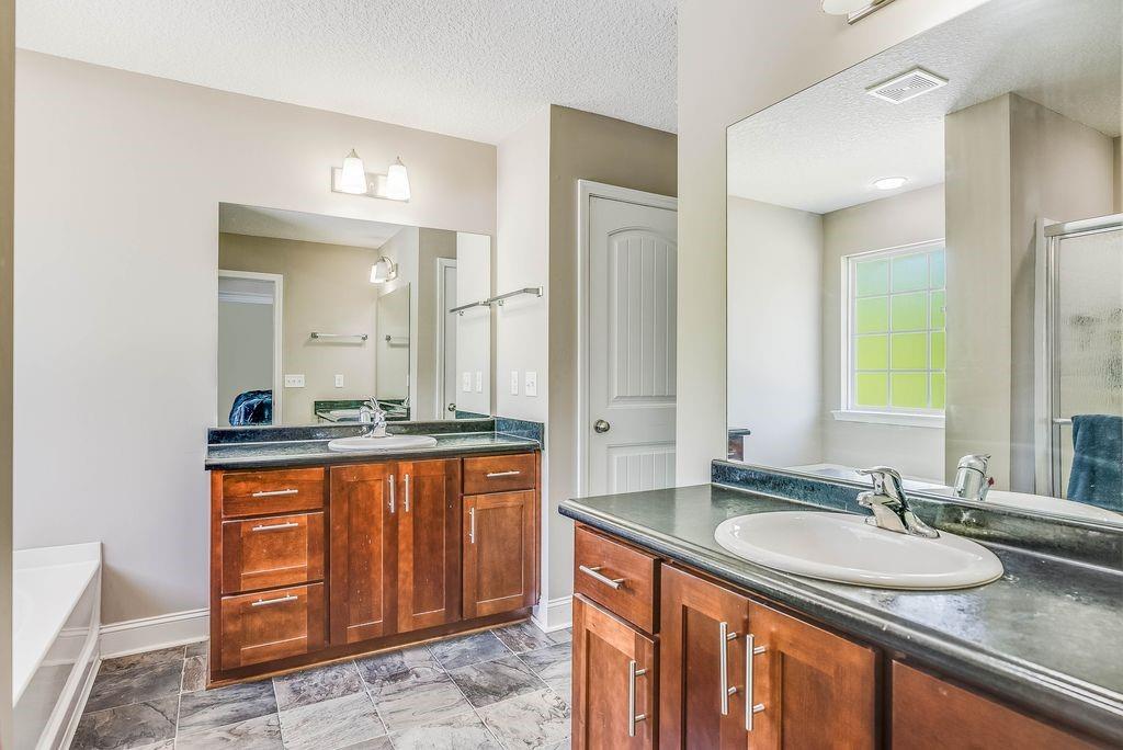 1200 Cypress Fall Circle Hinesville, GA 31313 - Photo 17 of 24 a bathroom with a granite countertop sink and a mirror