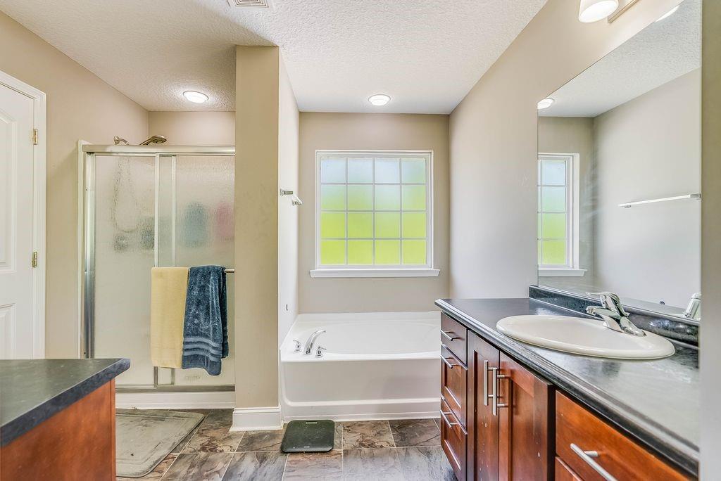 1200 Cypress Fall Circle Hinesville, GA 31313 - Photo 18 of 24 a bathroom with a granite countertop sink and a bathtub