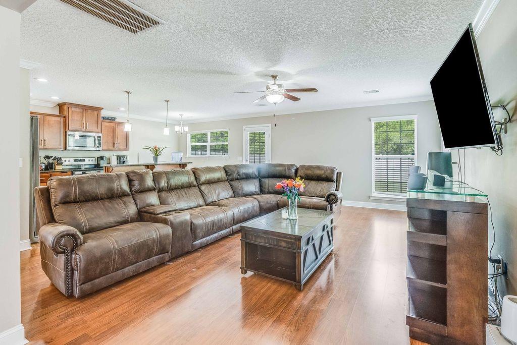 1200 Cypress Fall Circle Hinesville, GA 31313 - Photo 2 of 24 a living room with furniture a flat screen tv and kitchen view
