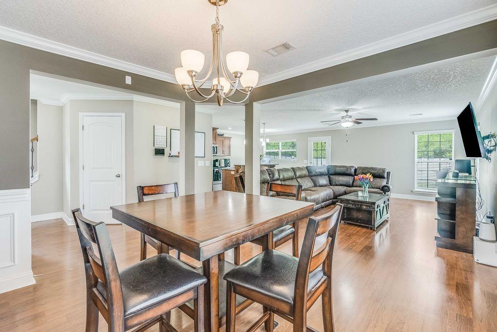 1200 Cypress Fall Circle Hinesville, GA 31313 - Photo 5 of 24 a view of a dining room with furniture wooden floor and chandelier
