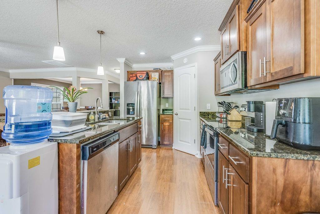 1200 Cypress Fall Circle Hinesville, GA 31313 - Photo 7 of 24 a kitchen with stainless steel appliances granite countertop a stove and a sink