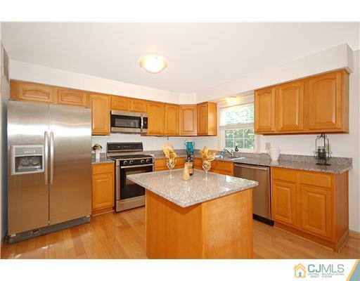 3801 Springbrook Drive Edison, NJ 08820 - Photo 4 of 13 a kitchen with stainless steel appliances granite countertop a sink stove and refrigerator
