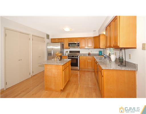 3801 Springbrook Drive Edison, NJ 08820 - Photo 5 of 13 a kitchen with stainless steel appliances granite countertop a sink and cabinets