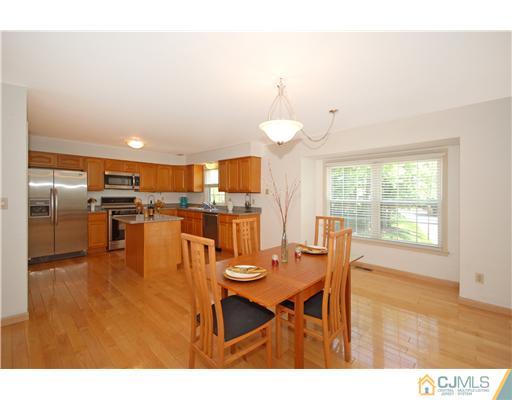 3801 Springbrook Drive Edison, NJ 08820 - Photo 6 of 13 a kitchen with stainless steel appliances kitchen island granite countertop a table chairs and a refrigerator