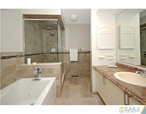3801 Springbrook Drive Edison, NJ 08820 - Photo 10 of 13 a bathroom with a granite countertop sink a mirror and a bathtub