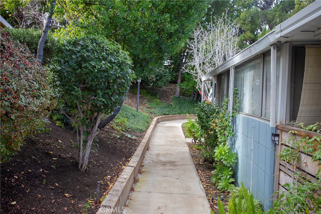 26713 Oak Crossing Road, Unit B Newhall, CA 91321 - Photo 1 of 1 a view of a pathway with plants and large trees