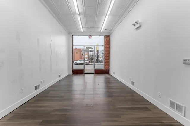 a view of a hallway with wooden floor and a couch