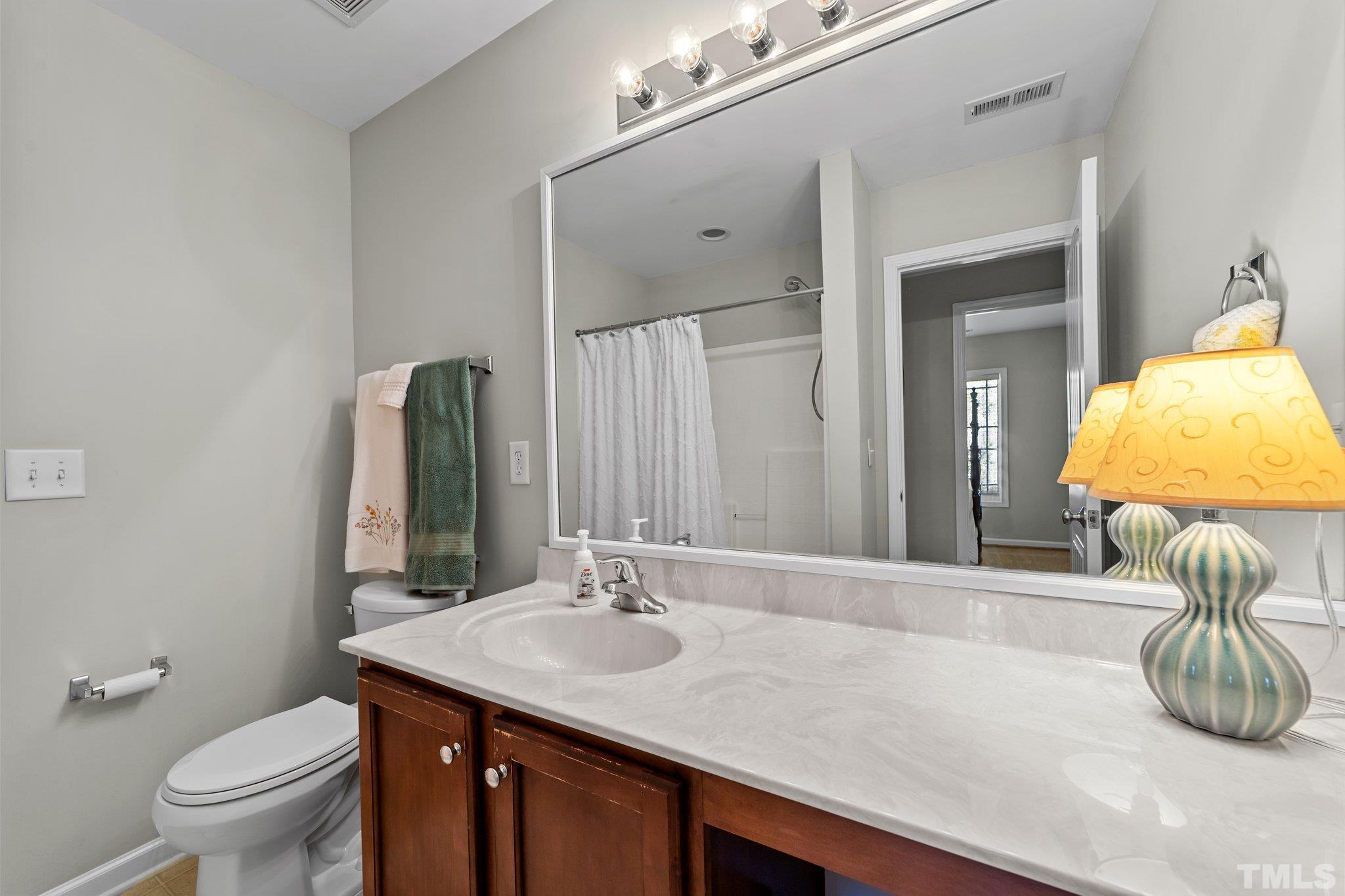 4728 Altha Street Raleigh, NC 27606 - Photo 21 of 31 a bathroom with a granite countertop sink and a mirror