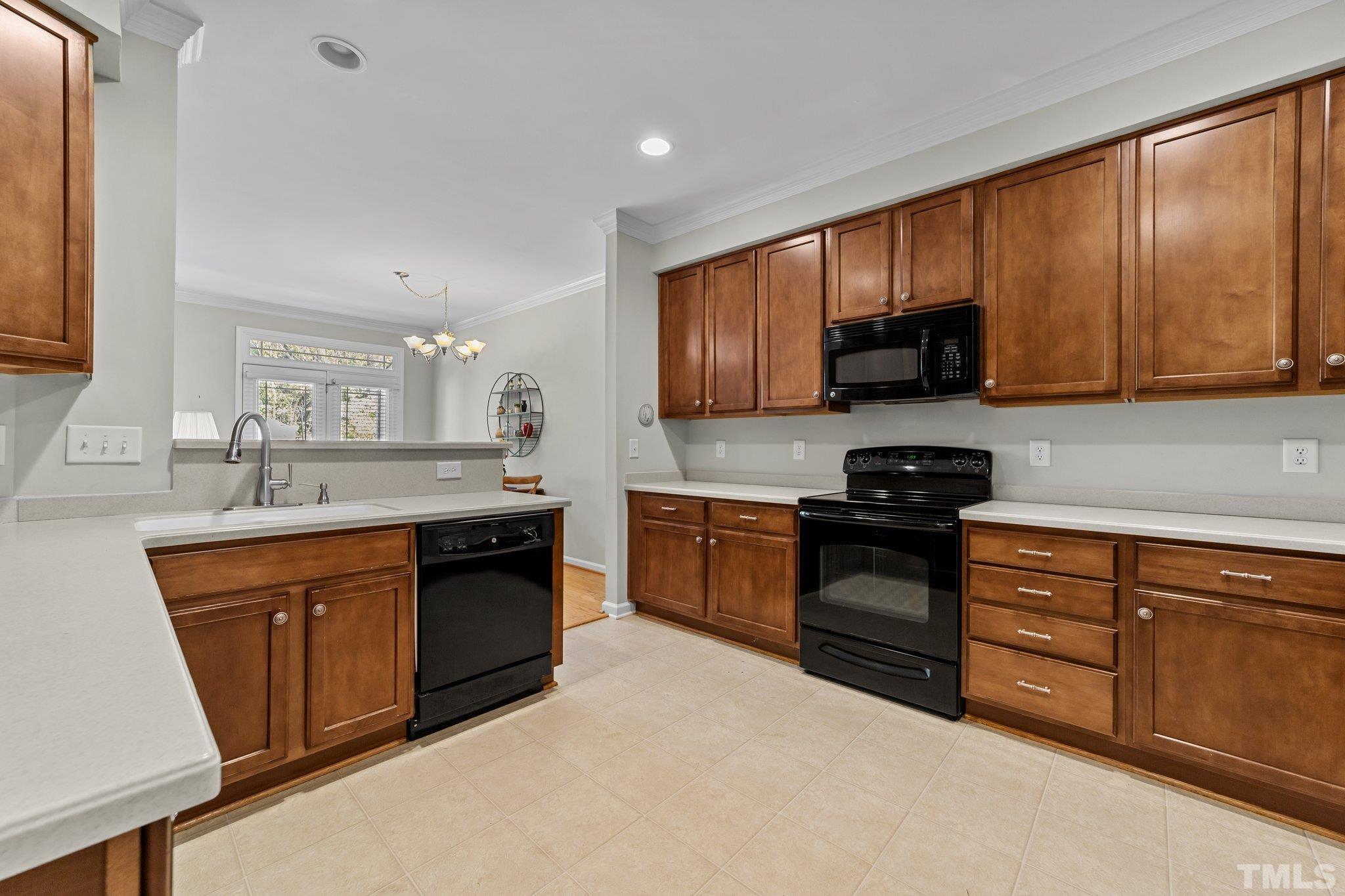 4728 Altha Street Raleigh, NC 27606 - Photo 7 of 31 a kitchen with stainless steel appliances granite countertop wooden cabinets a stove top oven a sink and dishwasher
