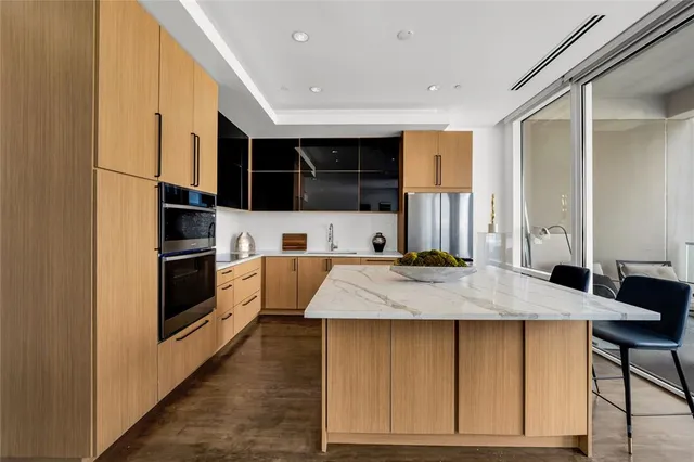 a large kitchen with kitchen island a sink stainless steel appliances and cabinets