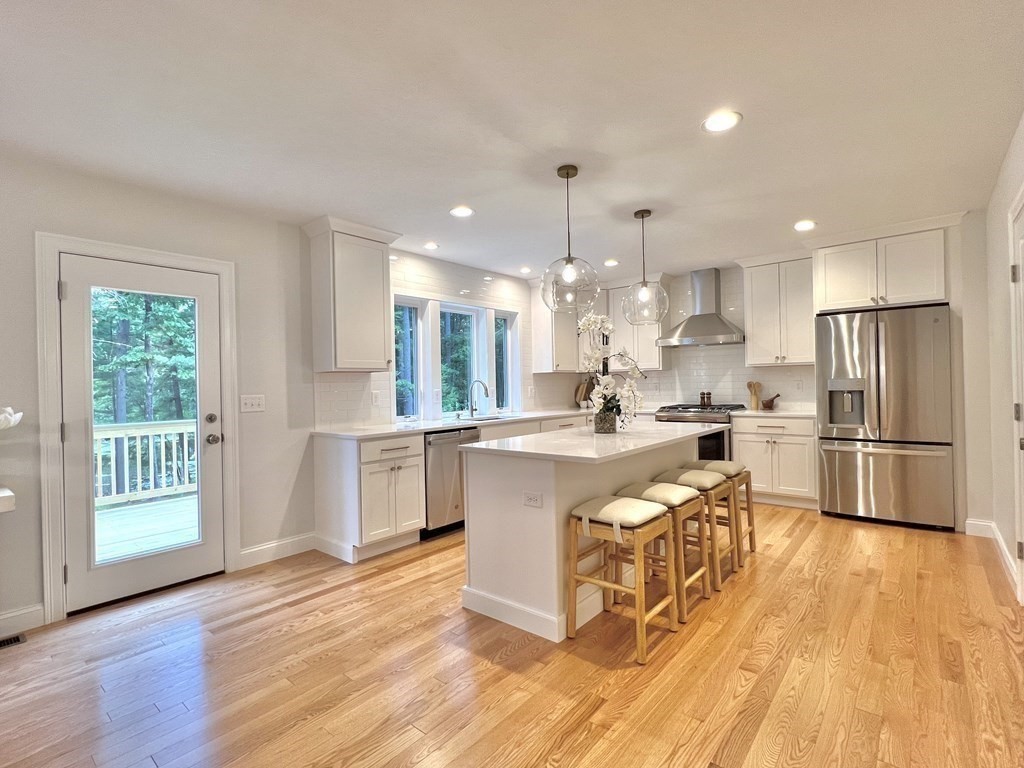 9 Shaker Pond Road Ayer, MA 01432 - Photo 9 of 16 a large kitchen with cabinets wooden floor stainless steel appliances and windows