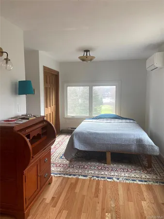 a view of a bedroom with wooden floor and a window