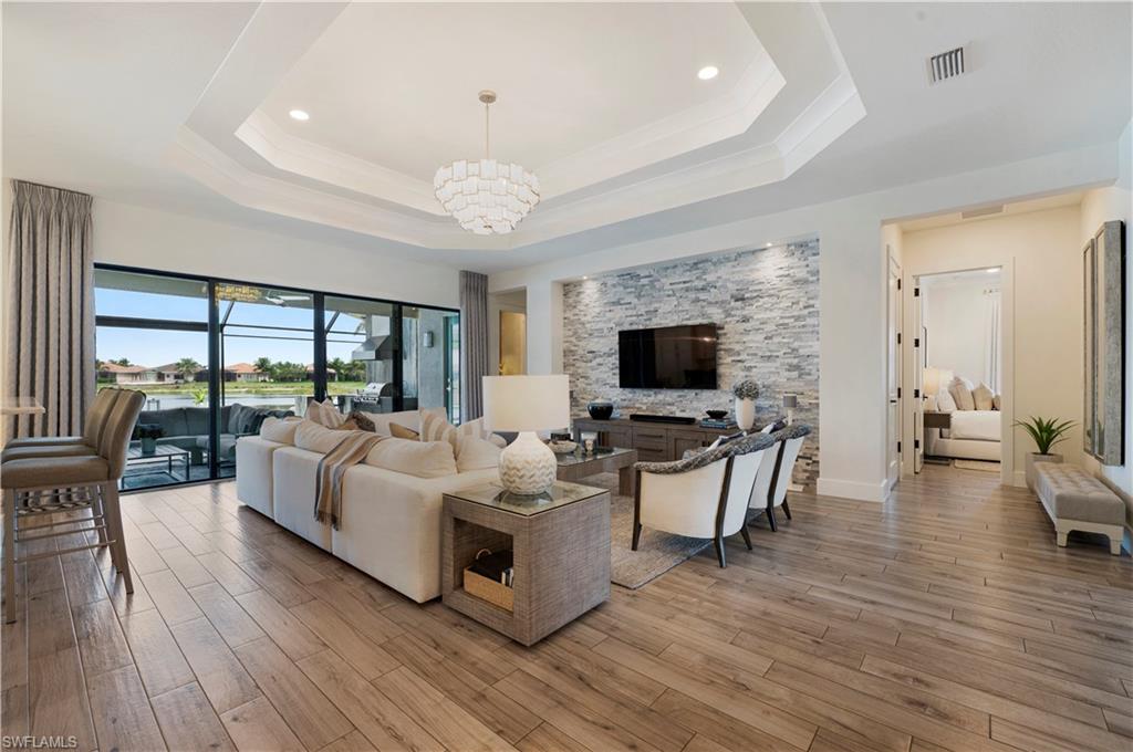 4353 Caldera Circle Naples, FL 34119 - Photo 11 of 40 a living room with furniture flat screen tv and a large window