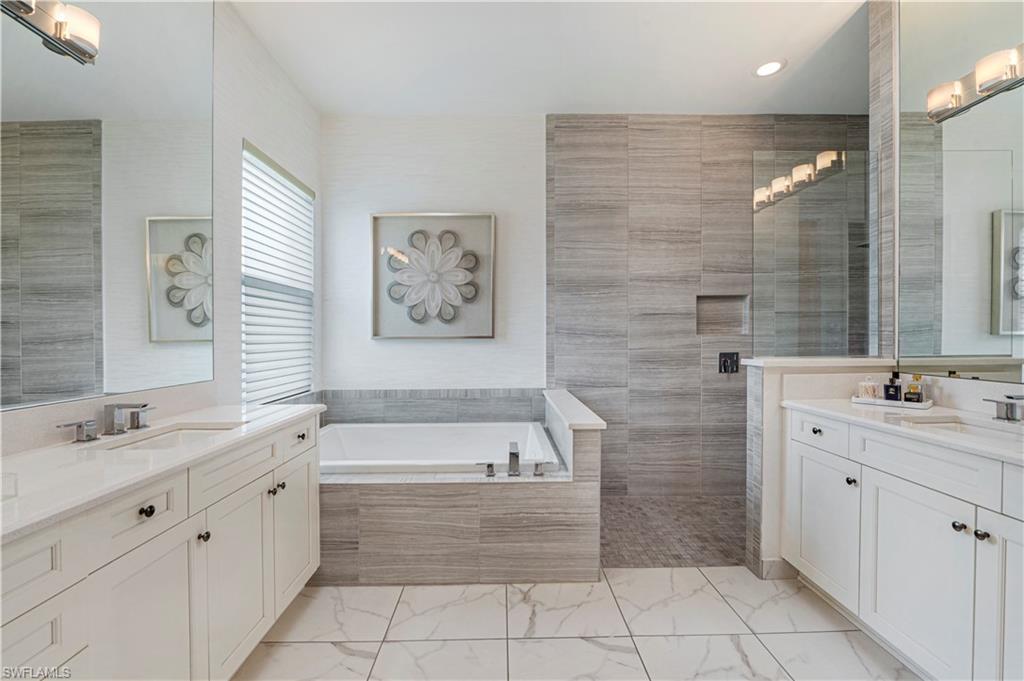 4353 Caldera Circle Naples, FL 34119 - Photo 15 of 40 a bathroom with a granite countertop sink a toilet a mirror and bathtub