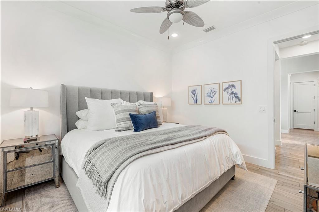 4353 Caldera Circle Naples, FL 34119 - Photo 19 of 40 a bed room with a bed and a chandelier