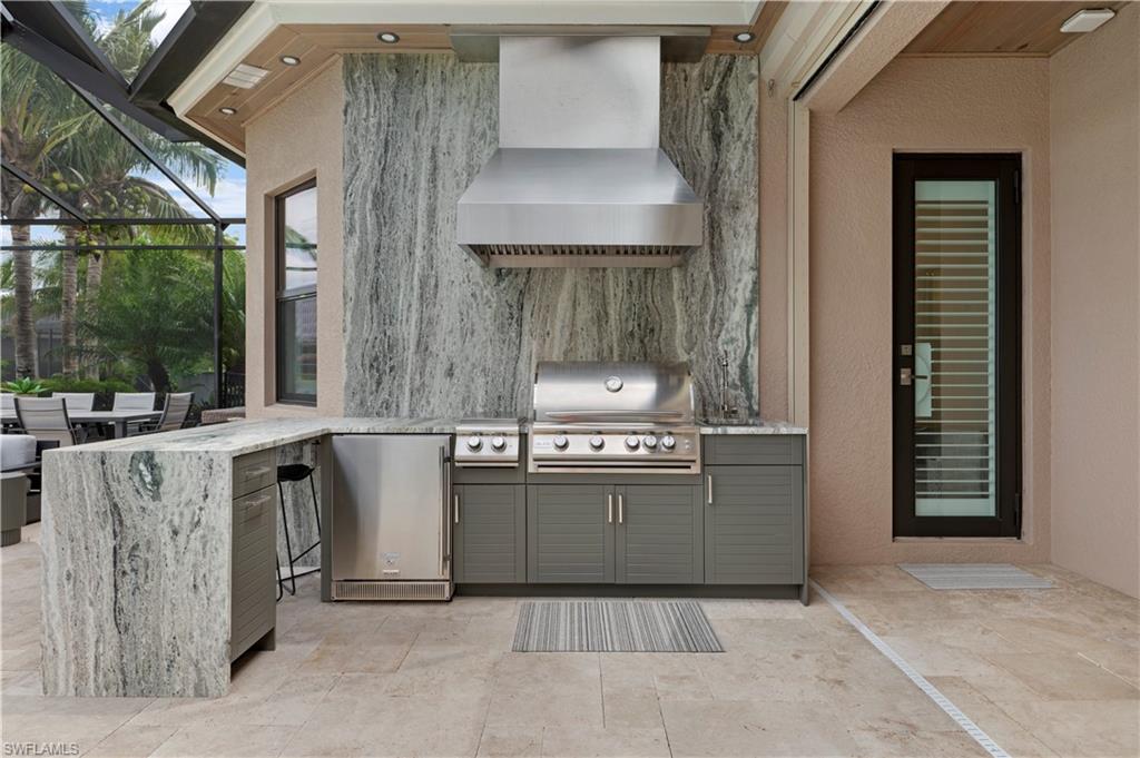 4353 Caldera Circle Naples, FL 34119 - Photo 26 of 40 a kitchen with stainless steel appliances granite countertop a stove a sink and a refrigerator