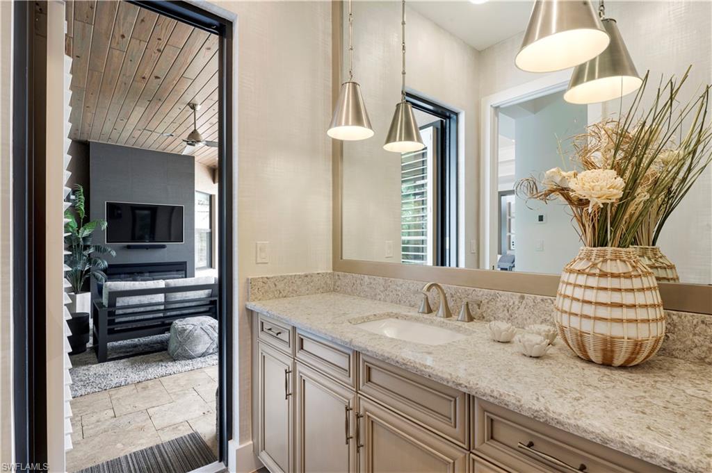 4353 Caldera Circle Naples, FL 34119 - Photo 31 of 40 a bathroom with a granite countertop sink and a mirror