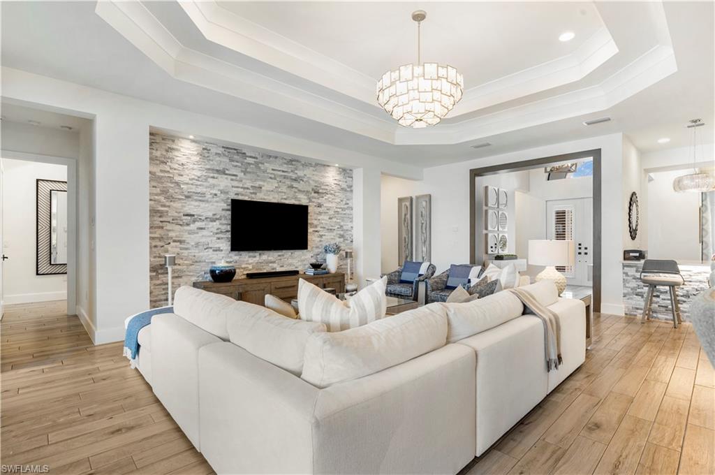 4353 Caldera Circle Naples, FL 34119 - Photo 8 of 40 a living room with furniture a flat screen tv and a fireplace