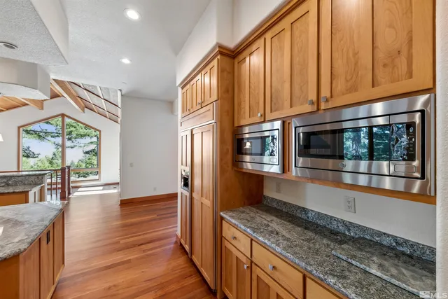 a kitchen with stainless steel appliances granite countertop a stove a sink and a microwave