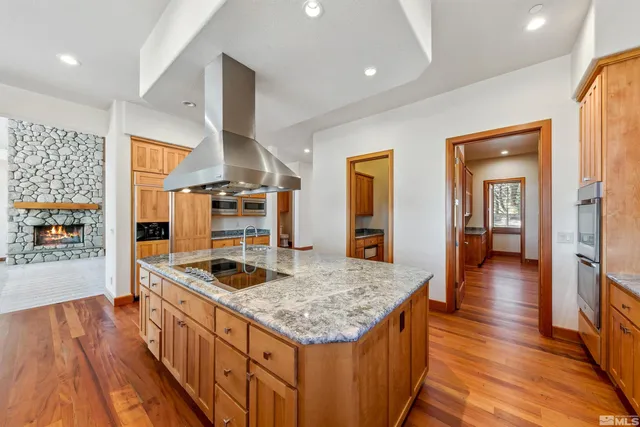a kitchen with granite countertop a stove and a wooden floors