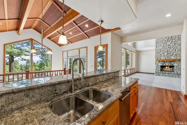a kitchen with a sink and large windows